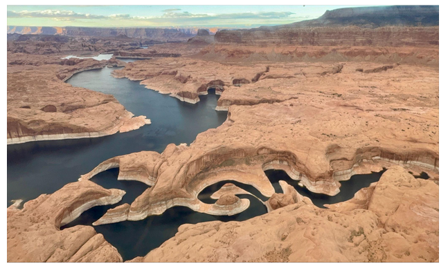 Aerial view of winding river through rocky desert landscape.