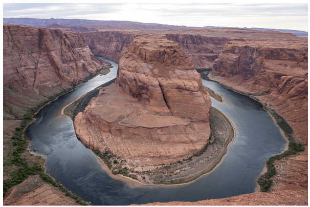 Aerial view of Horseshoe Bend with river curving around red rock formation.