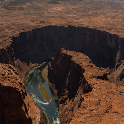 Aerial view of a canyon with a river winding through it.