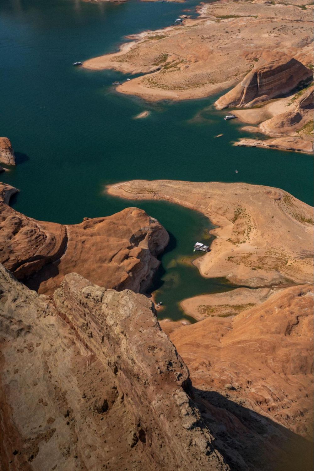 Aerial view of a canyon landscape with a river winding through red rock formations.