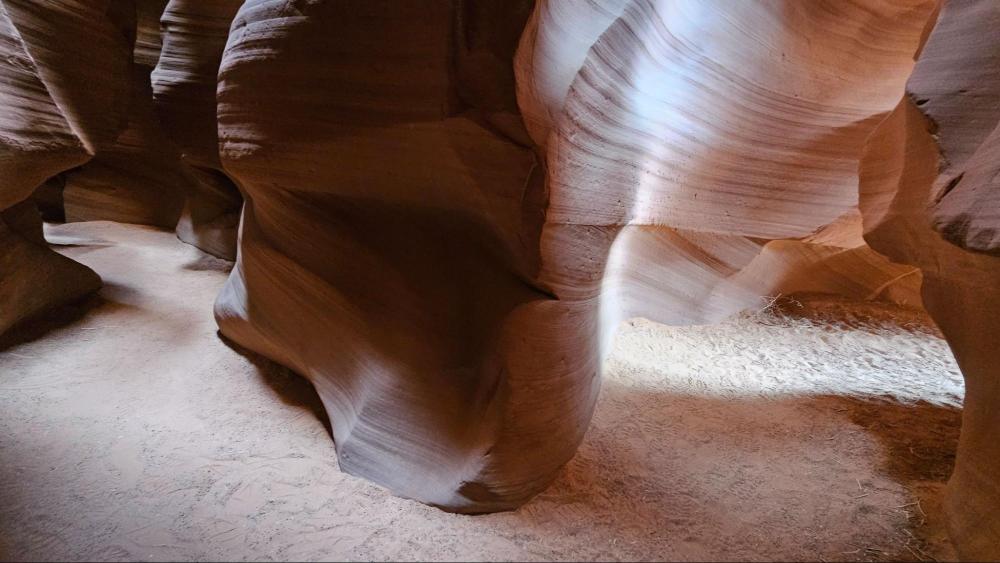 Sunlight illuminating curves of Antelope Canyon's sandstone walls.