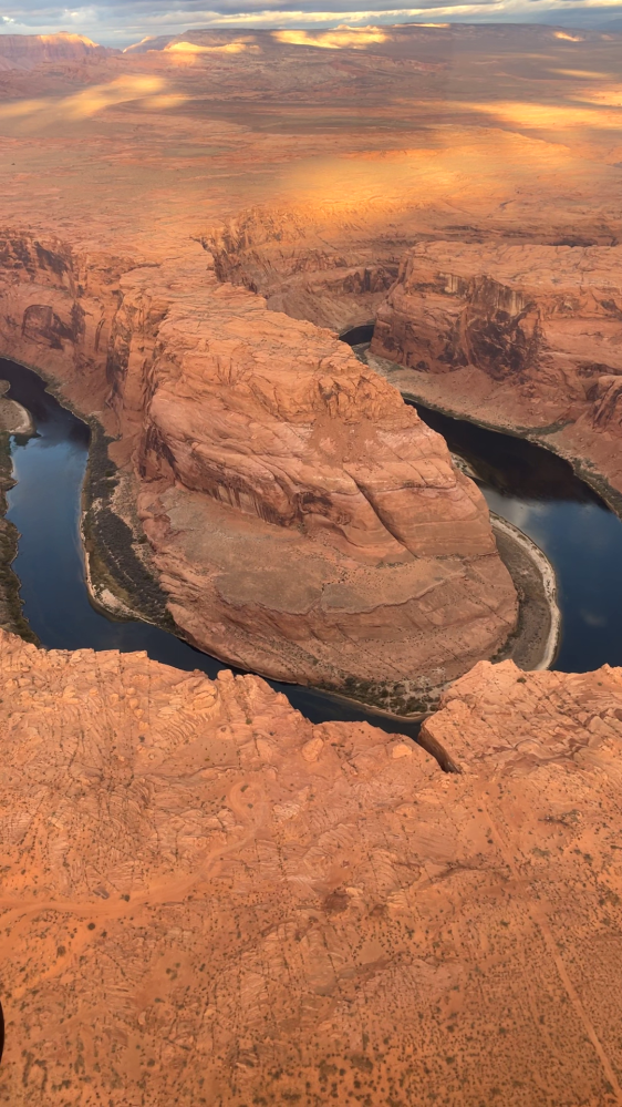 Aerial view of a meandering river cutting through red rock canyons.