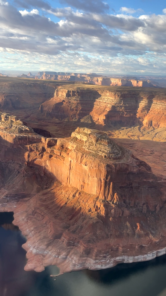 Aerial view of canyon landscape with cliffs and river below.