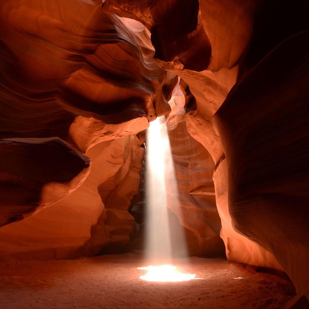 Sunbeam piercing through narrow, red rock canyon.